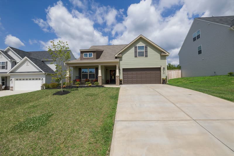 Long concrete driveway across a lawn to a two-car garage