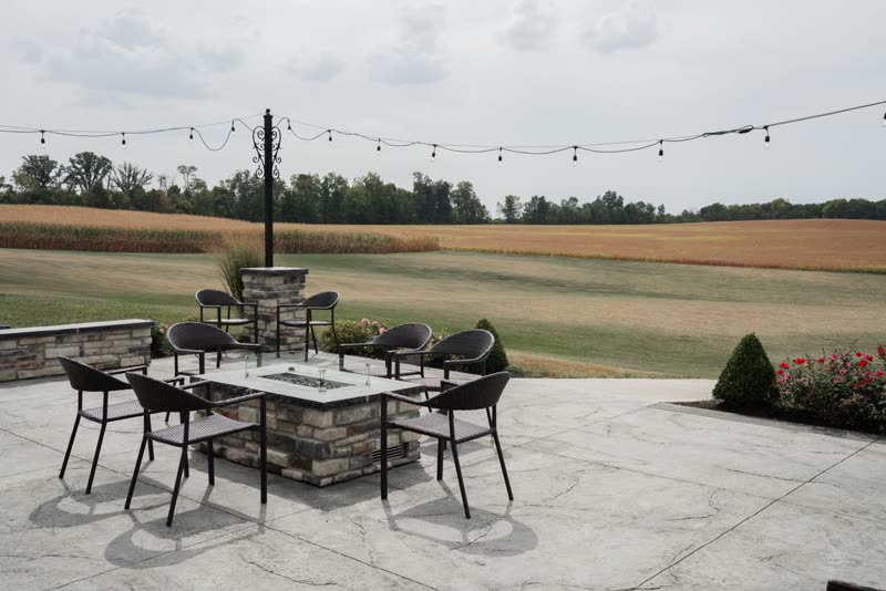 Large patterned patio with a dining set and a fire table